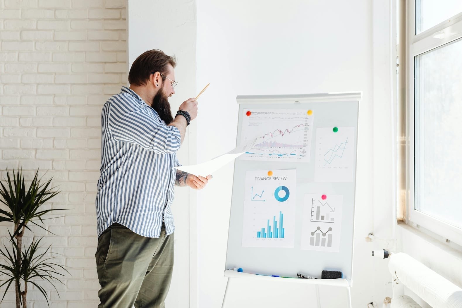 Mann analysiert Diagramme und Finanzdaten an Flipchart im Büro.